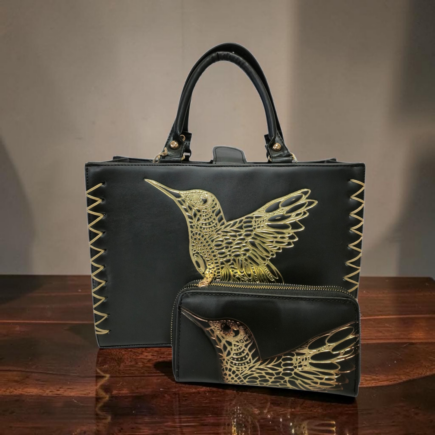 Bolsa artesanal negra con colibrí dorado en relieve y cartera a juego