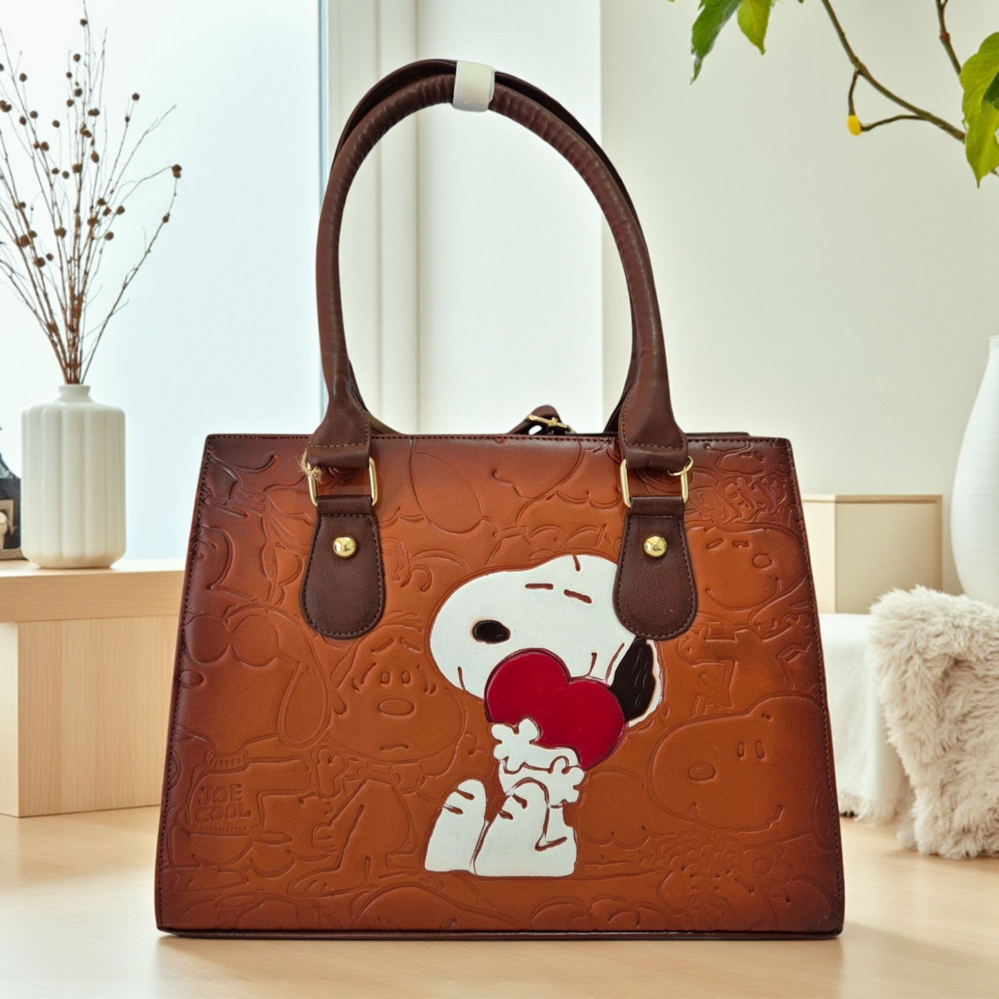 Bolsa artesanal de piel café con diseño grabado de personaje abrazando a un corazón rojo