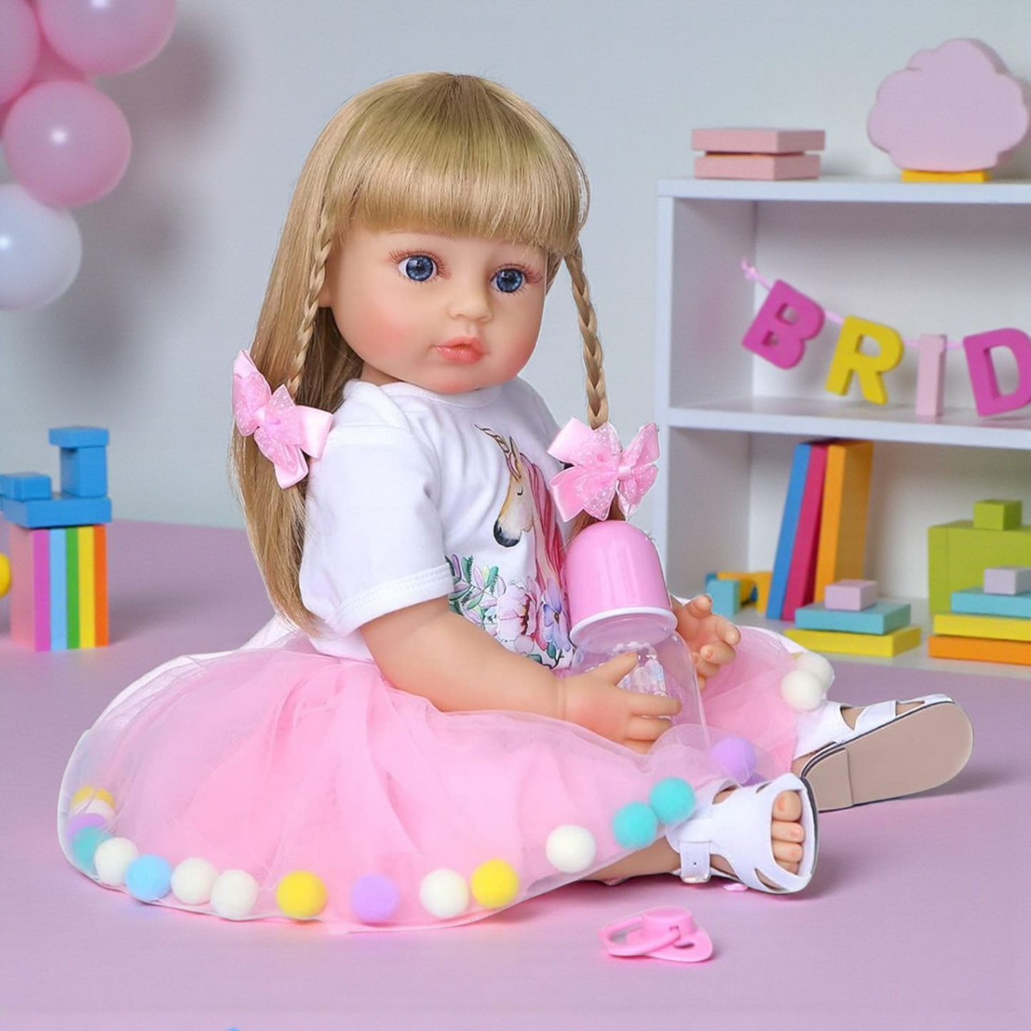 Muñeca bebé realista de vinilo 55 cm con cabello rubio y vestido rosa