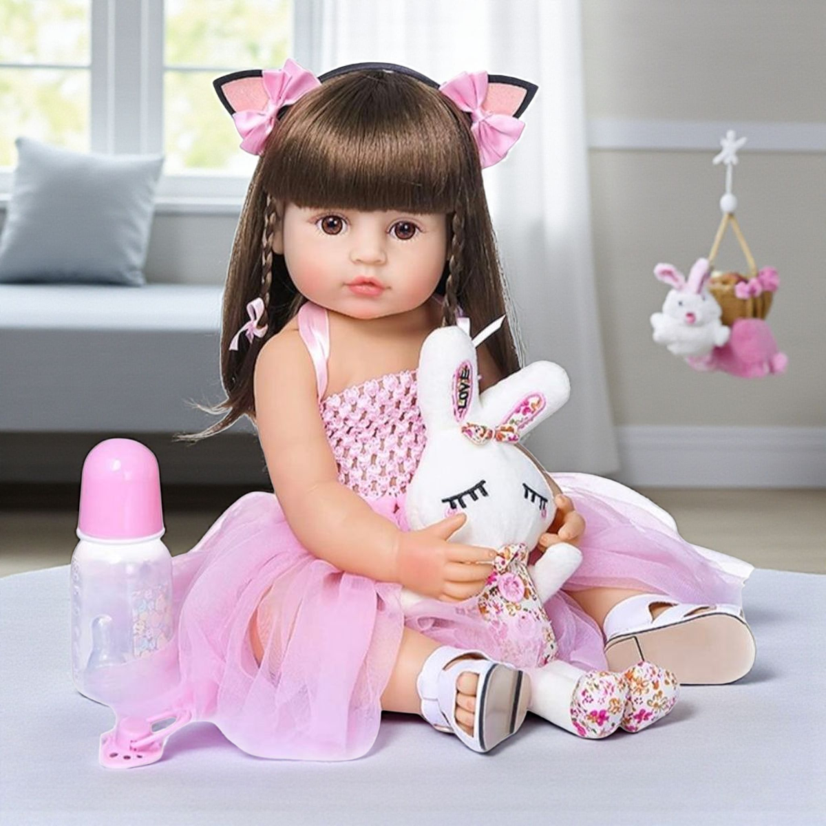 Muñeca bebé realista de vinilo 55 cm con cabello castaño y vestido rosa