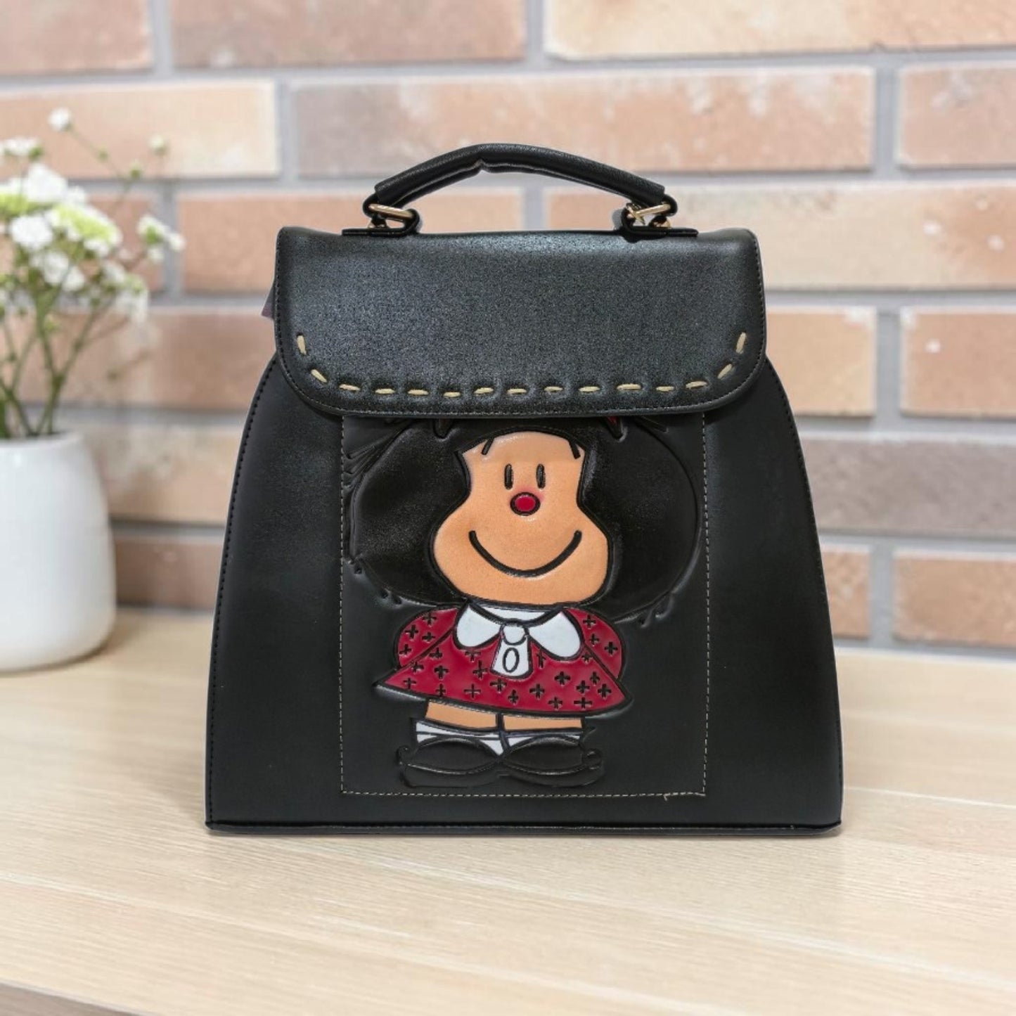 Black handbag with embossed design includes cosmetic bag